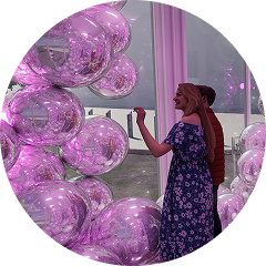 Person exploring an immersive installation of magenta molecule-like spheres