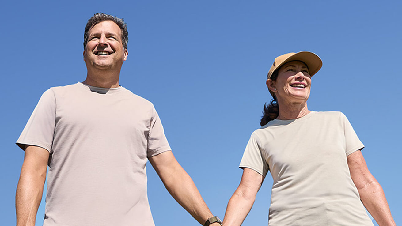 Photograph of individuals walking outdoors, featured in the patient stories section